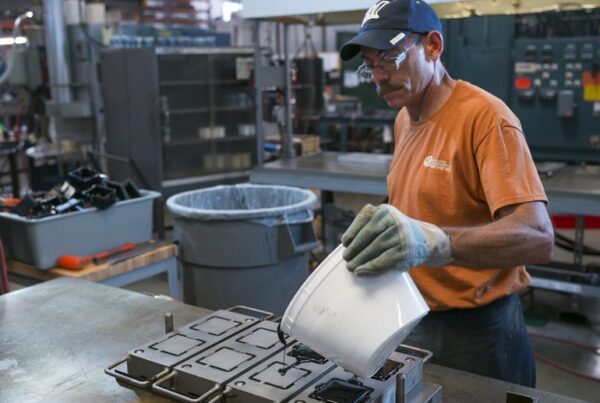 image from BizTimes article of a man pouring a rubber mold - uncertainty with tariffs